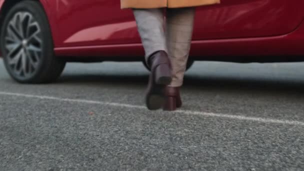 Mujer conductor se mete en el automóvil rojo en la calle de la ciudad de otoño — Vídeo de stock