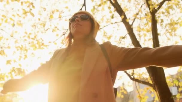 Positive lady with backpack turns around enjoying autumn — 비디오
