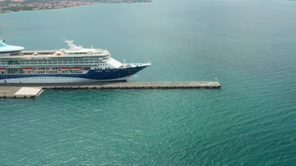 Aerial footage with zooming out from Aerial footage of a luxury cruise ship with a swimming pool on the roof moored in marina with turquoise sea water, October 2021, Zadar, Croatia — Wideo stockowe