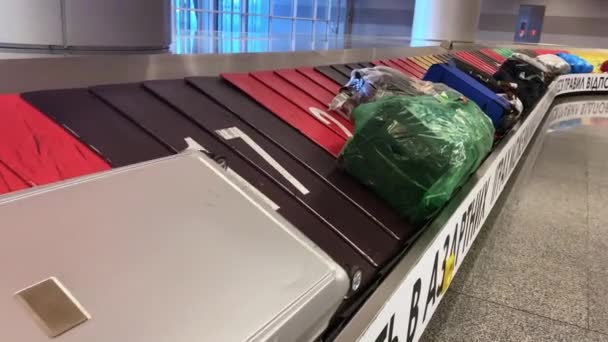 スーツケースと荷物はコンベアベルト上を移動します,現代ボリスピル空港の手荷物受取所, 2021年12月,キエフ,ウクライナ — ストック動画