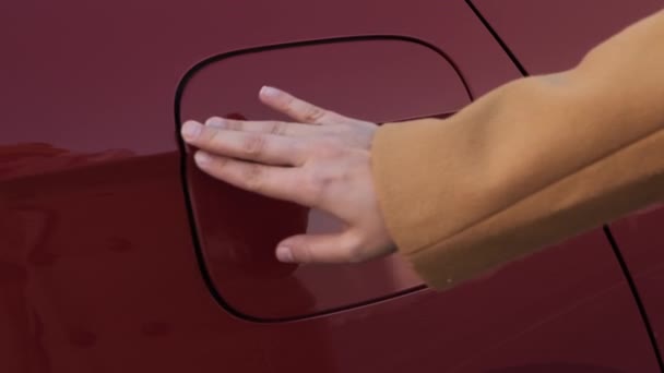 Cerca de la mano de la mujer abriendo la solapa de llenado de combustible del coche rojo — Vídeo de stock