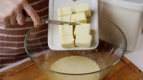 Woman puts butter cubes into bowl for making gingerbread — Stockvideo