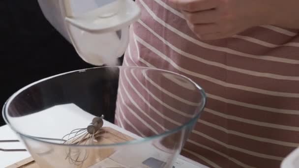 Mulher derrama açúcar em tigela de vidro preparando massa à mesa — Vídeo de Stock