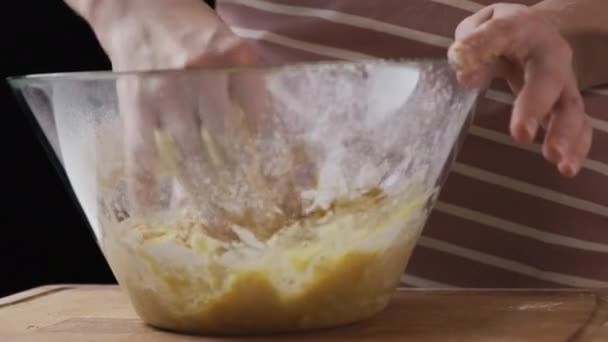 Женщина-пекарь разминает пряничное тесто в стеклянную миску — стоковое видео