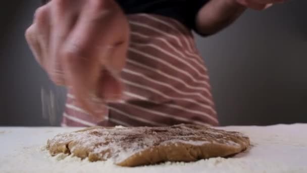 Чоловік посипає борошно на сире тісто для прокатки пряників — стокове відео