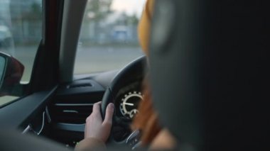 Şapkalı kadın sonbahar günü yol boyunca otomobil sürüyor.
