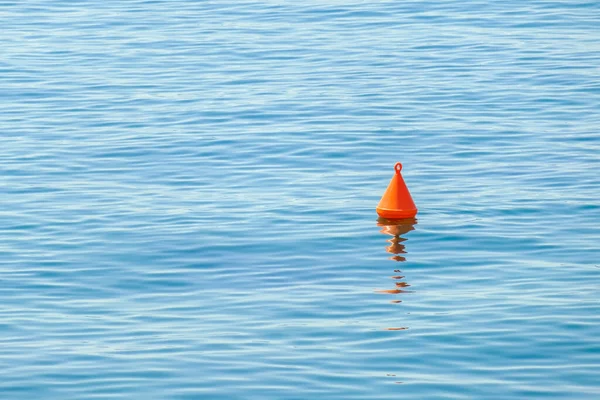 Bóia vermelha flutuando na superfície da água azul no mar — Fotografia de Stock