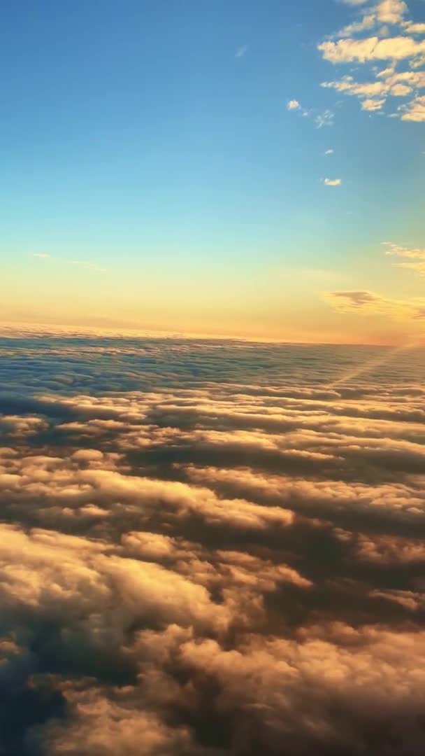 Vidéo verticale de nuages de coton duveteux rapides au coucher du soleil incroyable, vue aérienne de l'avion. Entre ciel et terre — Video