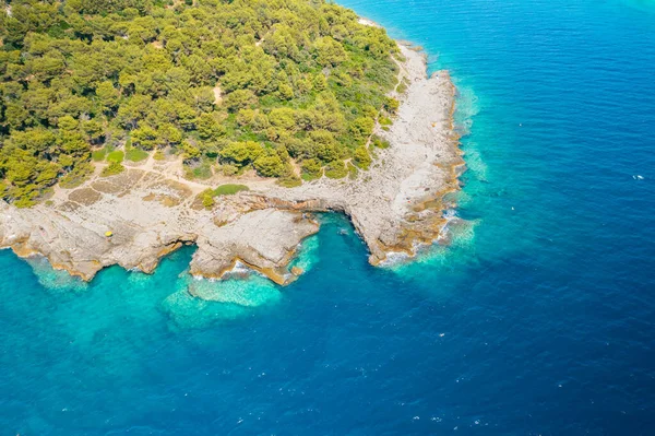 Şeffaf turkuaz su ve ormanlı kayalık kıyı manzarası. Denizdeki Akdeniz adası — Stok fotoğraf