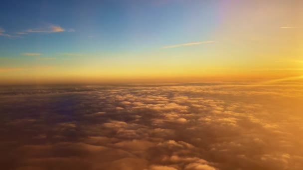 Latanie pod chmurami oświetlonymi na pomarańczowo przez promienie słońca o zachodzie słońca — Wideo stockowe