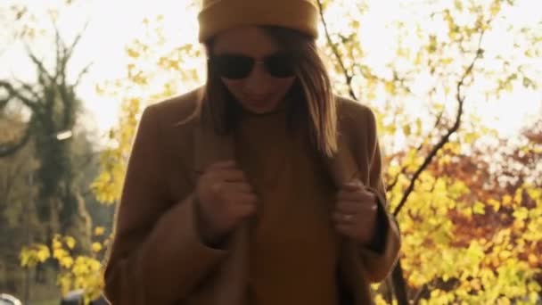 穿着外套和太阳镜的微笑的女人在森林里很开心 — 图库视频影像