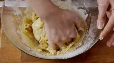 Kadın mutfakta cam kasede zencefilli ekmek için hamur yoğuruyor.