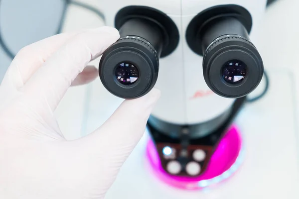 Закрыть руки ученого устанавливает микроскоп для анализа образца — стоковое фото