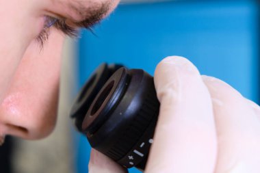 Bilimadamı, bilimsel genetik araştırma laboratuvarında elektronik mikroskopla deney yapıyor..