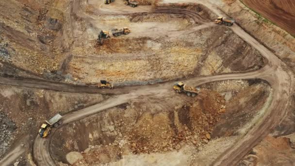 Vista aérea de camiones y excavadoras que transportan minerales desde una cantera — Vídeos de Stock