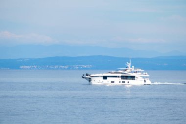 Büyük turist teknesi büyük dağlara karşı deniz suyunda yelken açar.
