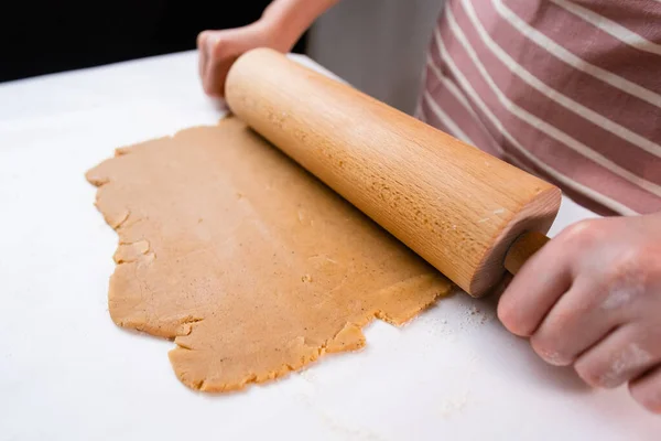 女性の手のトップビューは、ショートクラストペストリーからクッキーのための木製の圧延ピンで生地を展開 — ストック写真