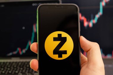 Zcash ZEC şifreleme logosu erkek eliyle akıllı telefon ekranında yeşil arka planda büyüyen bir eğilimle 