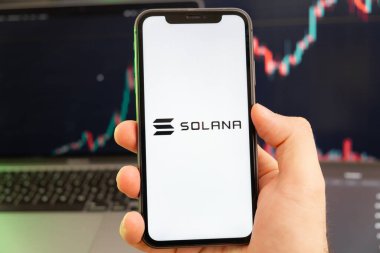 Solana SOL kripto para birimi logosu erkek eliyle akıllı telefon ekranında ve yeşil arkaplanda giderek artan bir eğilim var. 