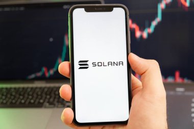 Solana SOL kripto para birimi logosu erkek eliyle akıllı telefon ekranında ve yeşil arkaplanda giderek artan bir eğilim var. 