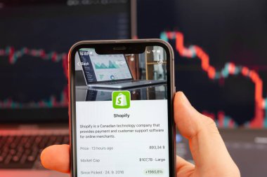 Arka planda kırmızı grafiklerle hisse senedi fiyatlarını düşür. Ekranda logosu olan akıllı telefonu tutan adam elleri, Şubat 2022, San Francisco, ABD