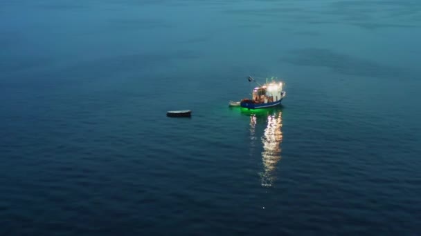 Abendfischen auf einem Schiff mit Lichtern, die auf dem Wasser reflektieren — Stockvideo