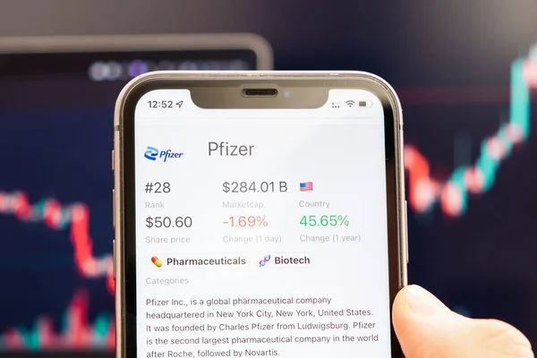 Pfizer-Aktienkurs auf dem Bildschirm des Mobiltelefons in der Hand mit sich verändernden Börsenkursen im Hintergrund, Februar 2022, San Francisco, USA — Stockfoto