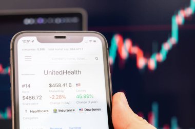 Birleşik Sağlık logosu akıllı telefon ekranında arka plandaki değişen eğilimle birlikte, Şubat 2022, San Francisco, ABD