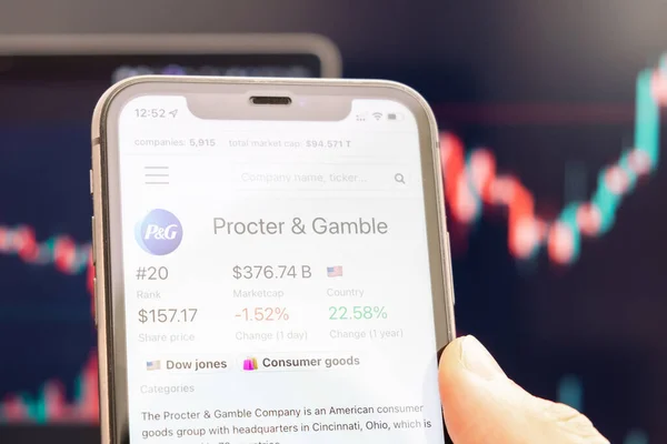 Procter and Gamble-Logo des Aktienkurses auf dem Bildschirm des Smartphones in der Hand mit sich änderndem Trend auf dem Chart im Hintergrund, Februar 2022, San Francisco, USA — Stockfoto