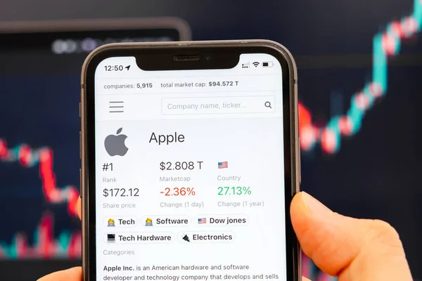 Logotipo da Apple de preço de ações na tela do smartphone em homens mão com tendência de mudança no gráfico em segundo plano, Fevereiro 2022, San Francisco, EUA — Fotografia de Stock