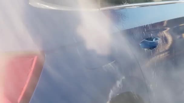 Чистка синього автомобіля з піни з чистою водою на станції — стокове відео