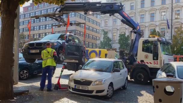 Ciężarówka holownicza zabiera samochód od ulicy pod kontrolą pracowników — Wideo stockowe