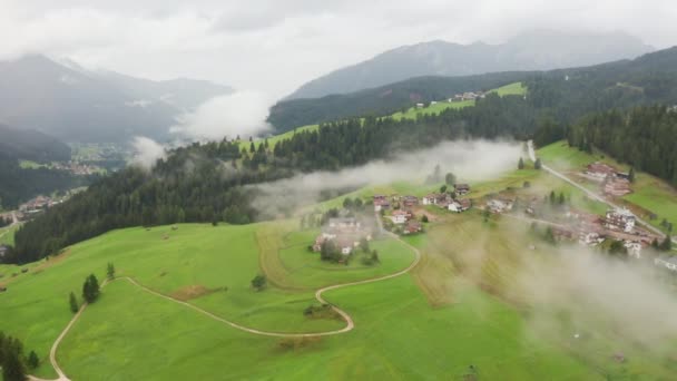 Vesnice poblíž lesa v údolí Alpské vrchoviny s tajemnou mlhou — Stock video