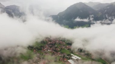 Yeşil vadideki küçük bir kasabada tüylü beyaz bulutlar