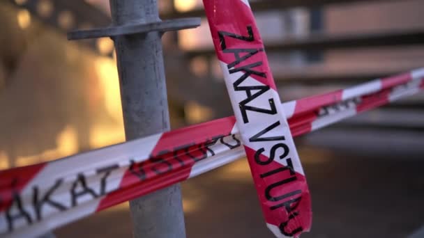 Red and white ribbons with inscription Zakaz vstupu in city — Stock Video