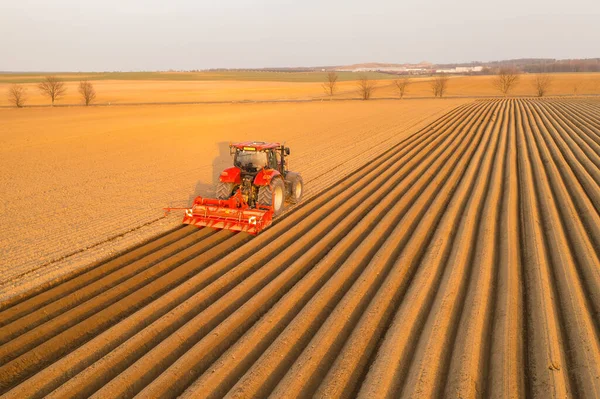 Heavy tractor uses plow to make beds for planting potatoes — Stock Photo, Image