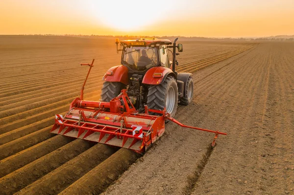 Tractor harrows in field dragging plow on purified soil — Stock Photo, Image