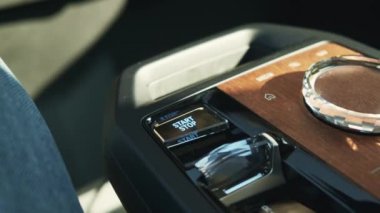 Adam, arabadaki multimedya sistem kontrolünde Başlat düğmesine basar