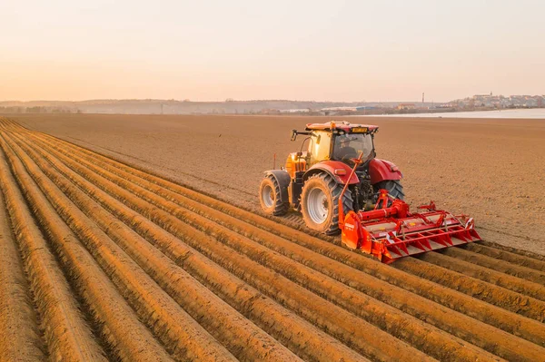 Heavy tractor uses plow to make beds for planting potatoes — Stock Photo, Image