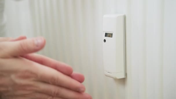 Meteran panas baterai dan manusia menghangatkan tangannya. Meningkatkan harga pemanas dan energi — Stok Video