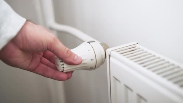 Homem mão regula o botão de temperatura do radiador de aquecimento para sala de aquecimento — Vídeo de Stock