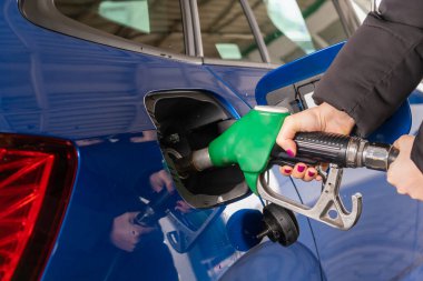 Kadın arabaya benzin dolduruyor. Yakıt fiyatlarında artış. Rusya 'ya ve petrol ambargosu konseptine karşı yaptırımlar