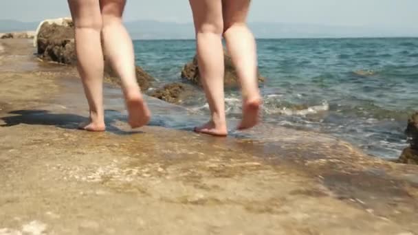 Dziewczyna przyjaciele spacer na mokry falochron myte przez fale morskie — Wideo stockowe