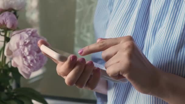 Young woman scrolls down news in Internet using smartphone — стоковое видео