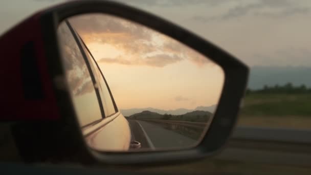 汽车的侧镜,反射橙色的落日和多云的天空 — 图库视频影像