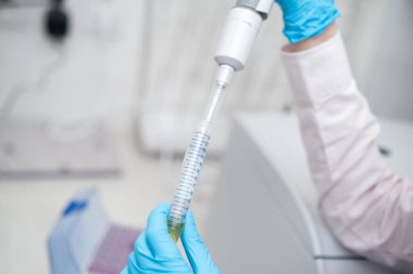 Bilim adamı örneği otomatik pipetle topluyor.. 