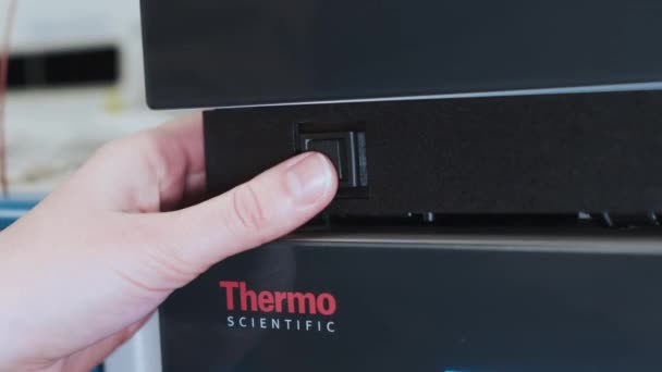Weibliche Hand schaltet HPLC System von Thermo Scientific ein. — Stockvideo