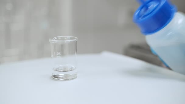 Close up laboratorium woker vullen van de bealer met oplosmiddel uit de fles wassen — Stockvideo
