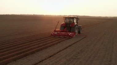  Gün batımında tarımda çalışan kırmızı traktör..