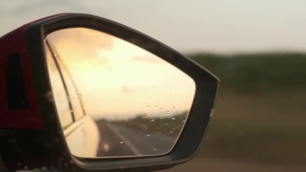 驾驶汽车的侧镜反射出明亮的橙色落日 — 图库视频影像